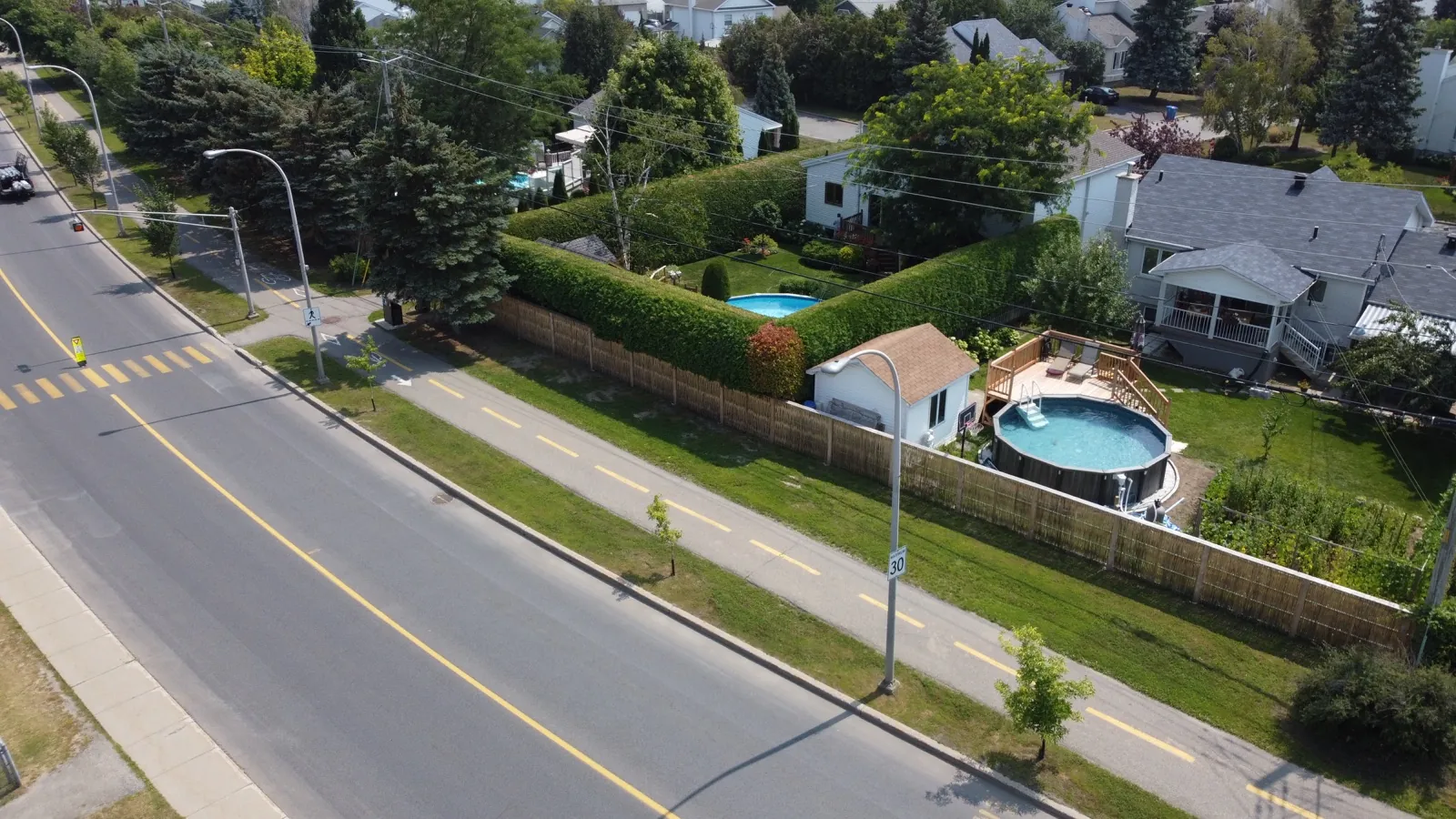 Vue drone (clôture en saule tressé séparant une zone résidentielle d'une rue à Saint-Constant)