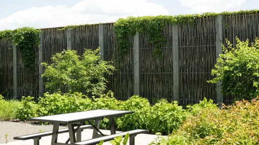 Mur antibruit Pilebyg® en saules, en bordure d’une aire de détente résidentielle
