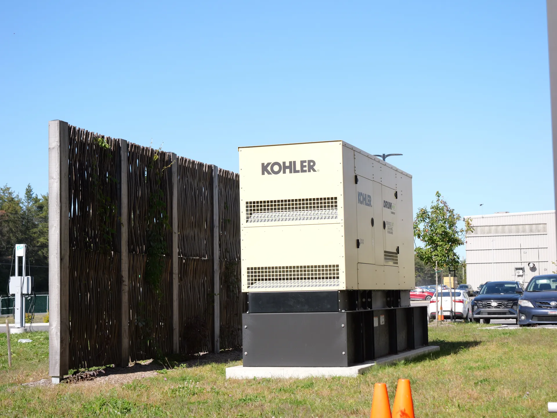 Clôture en saule tressé masquant une génératrice sur un site commercial, Québec