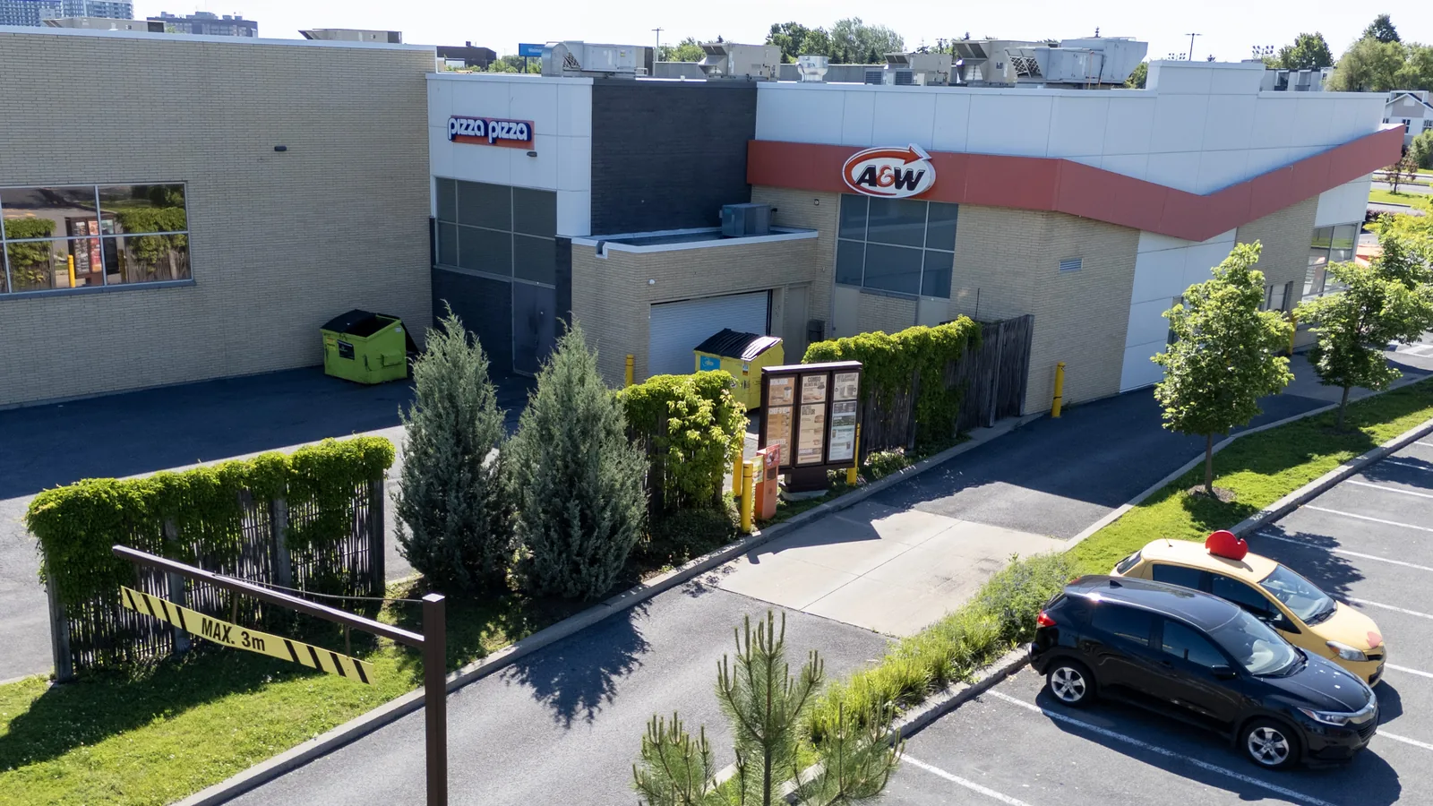 Clôture en saule tressé délimitant l'arrière-cour d'un restaurant A&W (vue aérienne), Québec