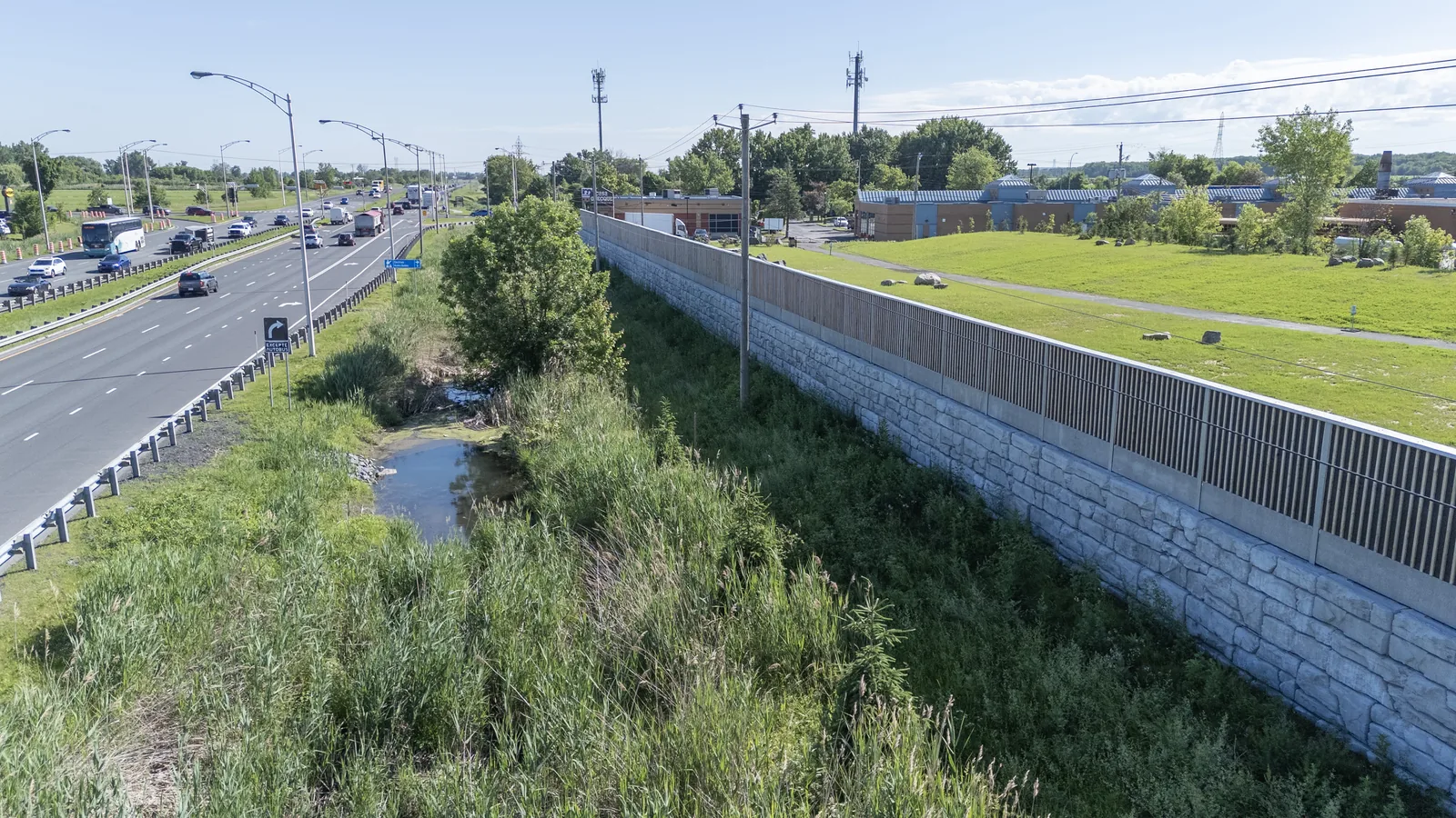 HF1 larch-wood noise barrier along a busy highway, Quebec