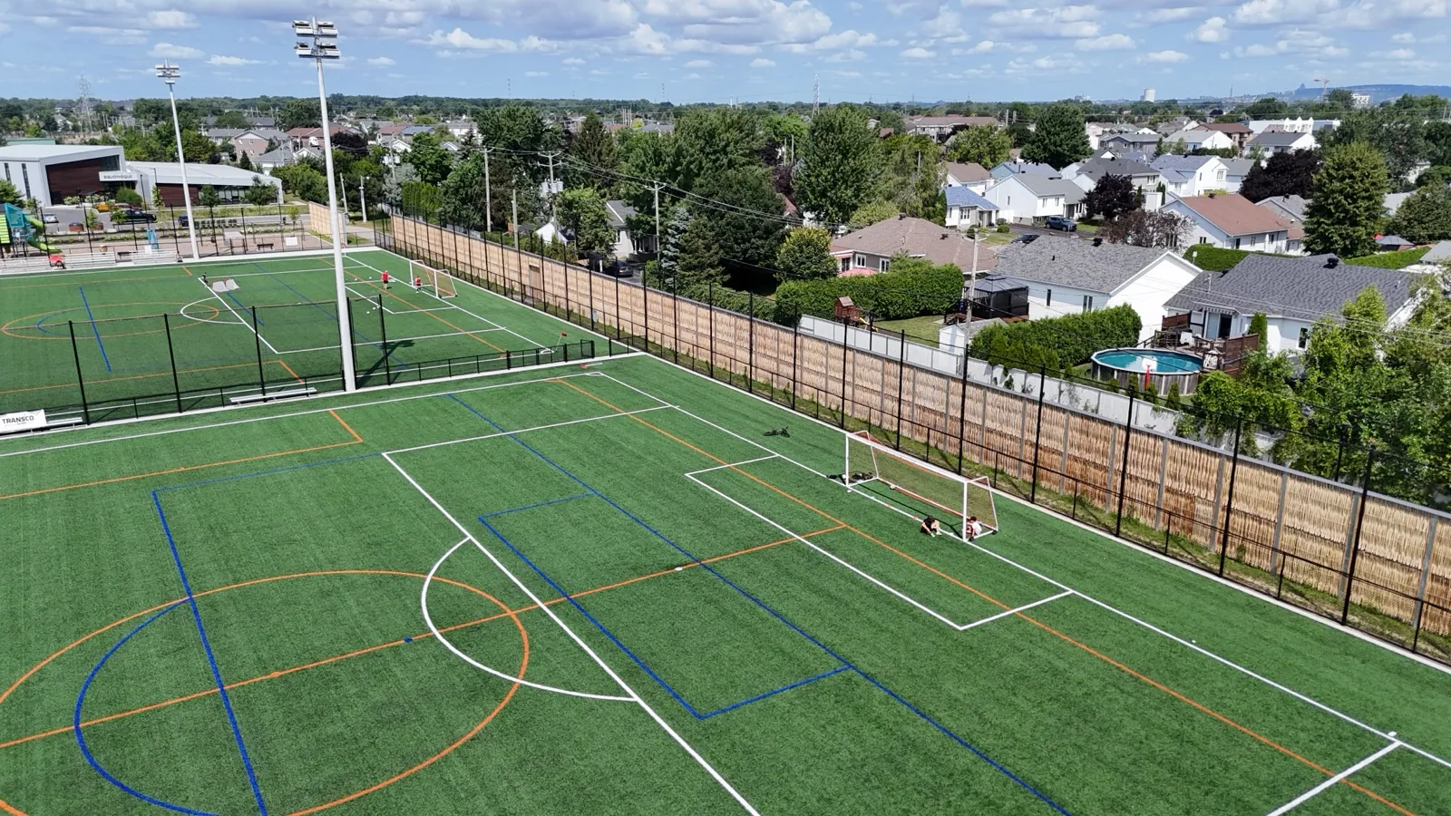 Pilebyg® willow-wood noise barrier around a soccer field, drone view, Quebec