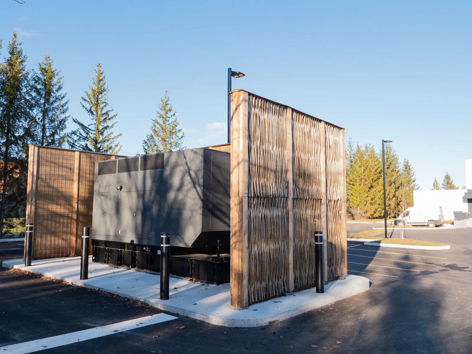 Pilebyg® willow-wood noise barrier concealing mechanical equipment in Quebec
