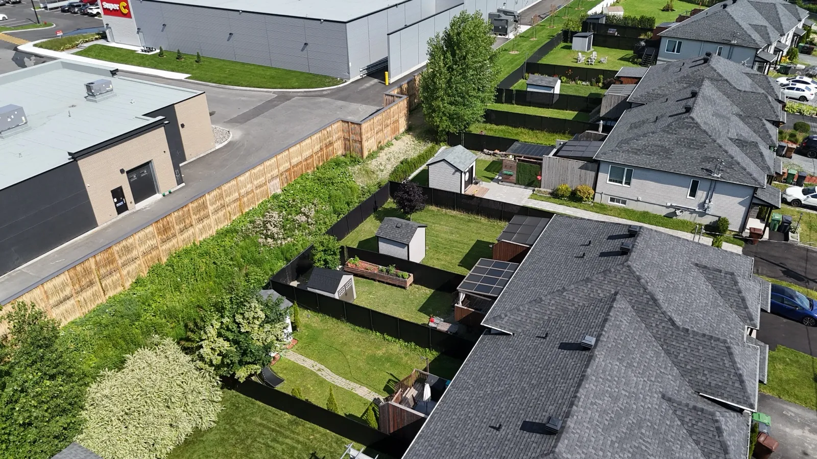 Willow-wood noise barrier separating a commercial area from homes, drone view, Quebec
